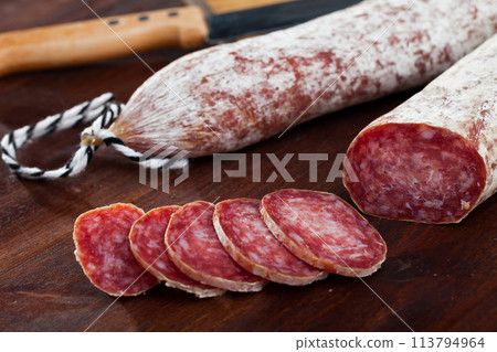 Spanish longaniza salami sausages cut in slices on a woodefn desk 113794964