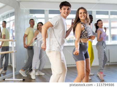 Smiling young girl and guy practicing lindy hop in studio 113794986