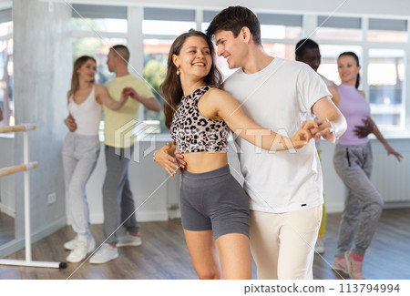 Man and young woman dancing waltz in couple during lesson at studio 113794994