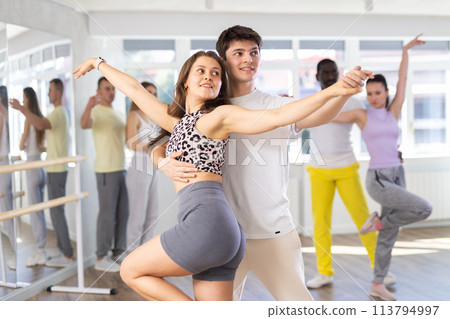 Man and young woman dancing waltz in couple during lesson at studio 113794997