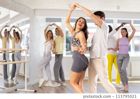 Young man and woman practicing tango dance in pair in training hall 113795021