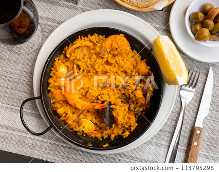 Spanish rice dish paella tinted with saffron. Prepared with olive oil and seafood 113795298