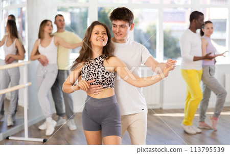 Young man and woman practicing salsa dance in pair in training hall 113795539