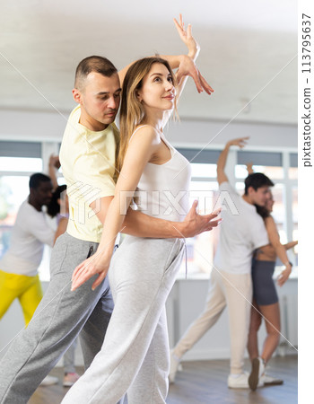 Man and young woman dancing waltz in couple during lesson at studio 113795637