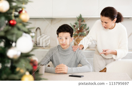Mother scolds her son for inappropriate behavior on Christmas holiday 113795697