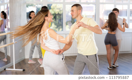 Man and young woman dancing waltz in couple during lesson at studio 113795887