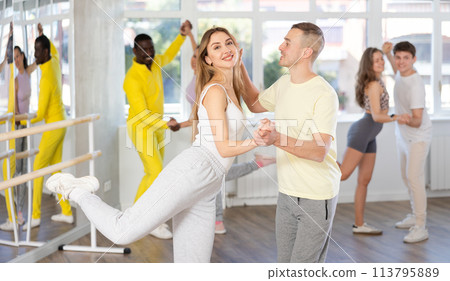 Young man and woman practicing waltz dance in pair in training hall Young man and woman practicing waltz dance in pair in training hall 113795889