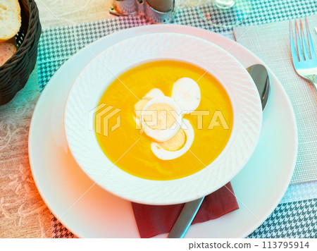 Pureed vegetable soup served with boiled eggs in bowl with spoon and glass of wine. Pureed vegetable soup served with boiled eggs in bowl with spoon and glass of wine. 113795914