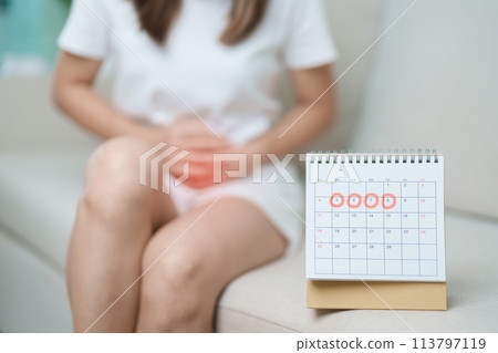 Menstruation period cycle of monthly and Stomachache concepts. woman having abdomen pain with calendar, illness female suffer from premenstrual ache and body Health problem on sofa at home Menstruation period cycle of monthly and Stomachache concepts. woman having abdomen pain with calendar, illness female suffer from premenstrual ache and body Health problem on sofa at home 113797119