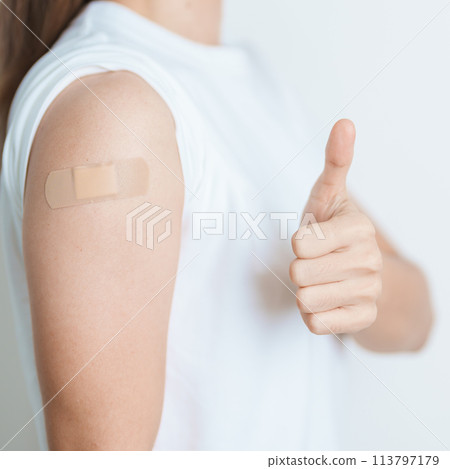 Woman with bandage after receiving vaccine. Vaccination and Immunization for Influenza, HPV, Zoster, IPD, DTP or Diphtheria, Tetanus and Pertussis, MMR, Hepatitis B, Covid  and Varicella vaccine 113797179