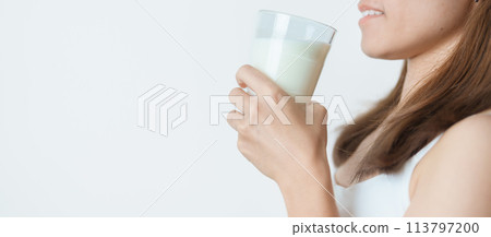 Milk drink and Daily Routine concept. Young woman Drinking milk with high calcium and nutrition at home, woman holding soy milk on glass with protein. Healthy, wellness and happy lifestyle Milk drink and Daily Routine concept. Young woman Drinking milk with high calcium and nutrition at home, woman holding soy milk on glass with protein. Healthy, wellness and happy lifestyle 113797200