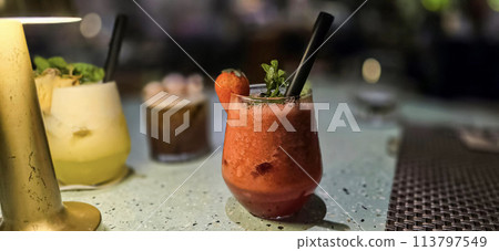 Fruit cocktail smoothie diet detox, tropical fruit summer cocktail with garnish, and ice on restaurant background 113797549