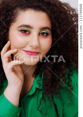 A woman with green and purple makeup on her face 113799988