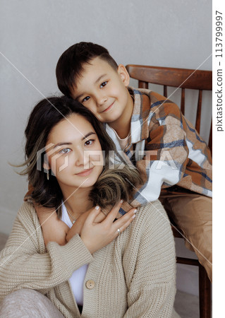 A mother and her son are hugging and smiling A mother and her son are hugging and smiling 113799997