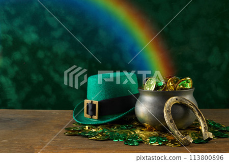 Saint Patrick's Day background. Black pot full of gold coins and leprechaun hat Saint Patrick's Day background. Black pot full of gold coins and leprechaun hat 113800896