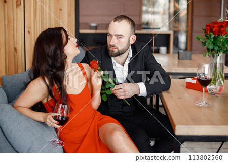 Romantic couple sitting in restaurant on a date and hugging 113802560