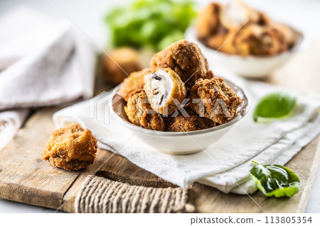Fried mushrooms in breadcrumbs in a white bowl. Homemade crispy deep fried mushrooms 113805354