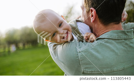 Father holding little baby, playing, having fun during warm spring day. Father's day concept. 113805443