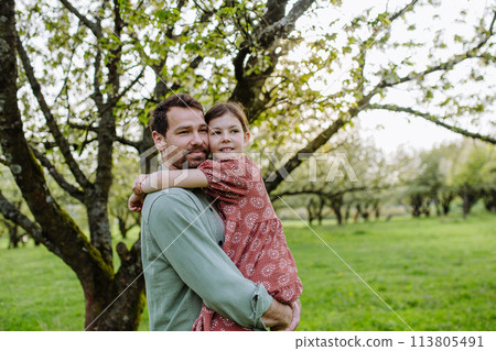 Father hugging his daughter in spring nature. Father's day concept. 113805491