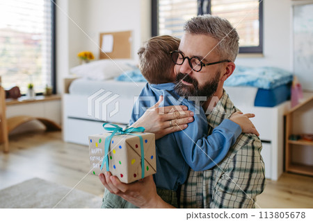 Dad get a handmade gift from little son, present wrapped in diy homemade wrapping paper. Happy Fathers day concept. Dad get a handmade gift from little son, present wrapped in diy homemade wrapping paper. Happy Fathers day concept. 113805678
