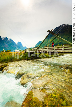 Tourist relaxing on bridge in village Oppstryn Norway 113806530