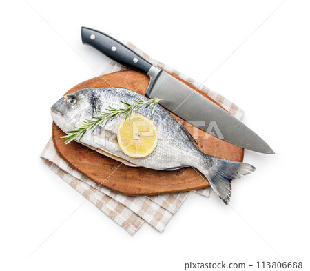 Fresh sea bream fish, rosemary and lemon on cutting board isolated on white background. Fresh sea bream fish, rosemary and lemon on cutting board isolated on white background. 113806688
