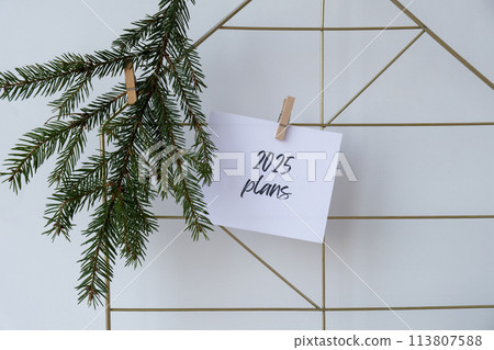 2025 PLANS text on white paper note on vision board with Christmas decor. New year aims resolutions. New me you concept visualizing 2025 PLANS text on white paper note on vision board with Christmas decor. New year aims resolutions. New me you concept visualizing 113807588