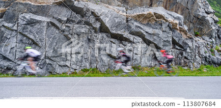 Blurry people driving bikes in mountains 113807684