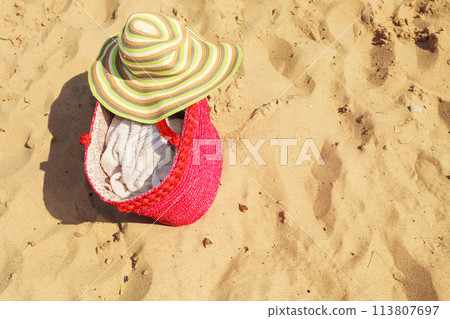 Summer hat and bag lying on beach. 113807697