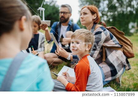 Students learning about renewable wind energy during field teaching class. Outdoor active education helping young student to learn about ecology and sustainability. 113807899