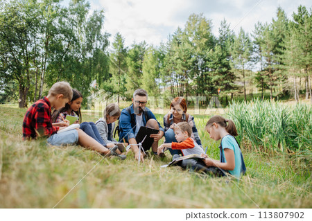 Students learning about renewable wind energy during field teaching class. Outdoor active education helping young student to learn about ecology and sustainability. Students learning about renewable wind energy during field teaching class. Outdoor active education helping young student to learn about ecology and sustainability. 113807902
