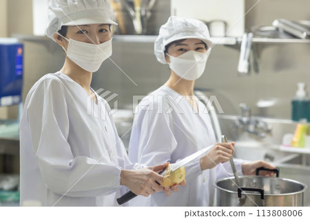 A woman wearing a lab coat and making a meal A woman wearing a lab coat and making a meal 113808006