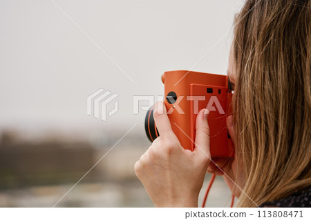 Female traveler taking picture with vintage instant camera Female traveler taking picture with vintage instant camera 113808471