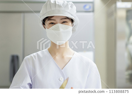 A woman wearing a lab coat and making a meal A woman wearing a lab coat and making a meal 113808875