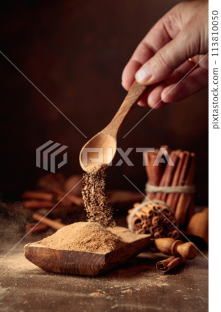 Cinnamon powder is poured into a wooden bowl. Cinnamon powder is poured into a wooden bowl. 113810050