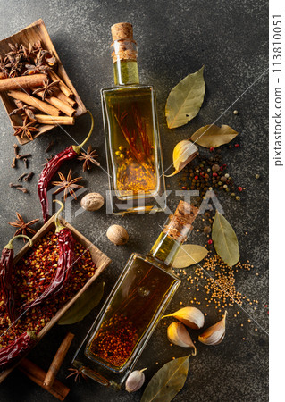 Bottles of olive oil and various spices on a kitchen table. Bottles of olive oil and various spices on a kitchen table. 113810051