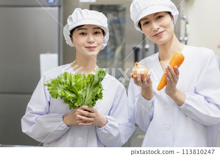 A woman wearing a lab coat and making a meal A woman wearing a lab coat and making a meal 113810247