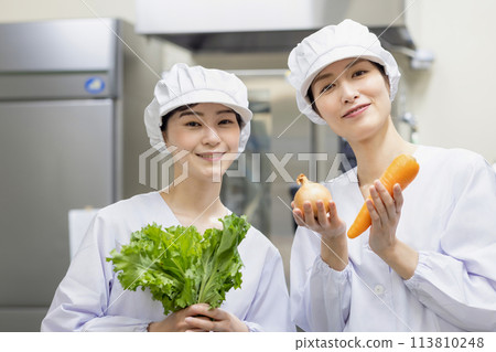 A woman wearing a lab coat and making a meal A woman wearing a lab coat and making a meal 113810248