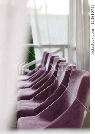Purple chairs stand in a row 113810735