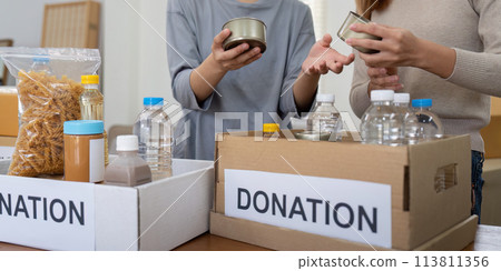 Volunteer preparing free foodstuff rations for poor people. Charity two woman of the community work together. concept of giving and humanitarian aid 113811356