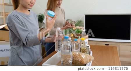 Donation and two woman volunteer asian of happy packing food in box at home. Charity 113811376