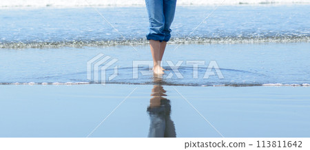 一個女人赤腳走在海灘上 113811642