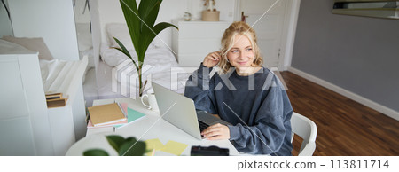 Portrait of woman sitting at desk with laptop, recording video of herself on laptop, making lifestyle video for social media account Portrait of woman sitting at desk with laptop, recording video of herself on laptop, making lifestyle video for social media account 113811714