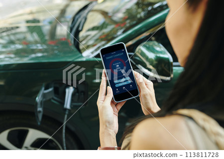 Diver showing electric car smart changer app Diver showing electric car smart changer app 113811728