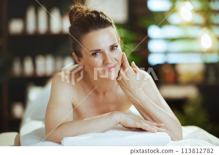relaxed female in massage cabinet laying on massage table 113812782