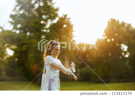 happy 40 years old woman in shirt using mites spray happy 40 years old woman in shirt using mites spray 113813174