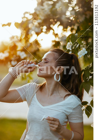 stylish woman in white shirt using nasal spray stylish woman in white shirt using nasal spray 113813192
