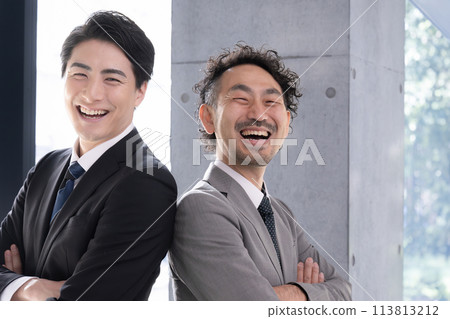 身穿西裝、雙臂交叉、背對背的商人抬頭看著他們的目標和未來。 113813212