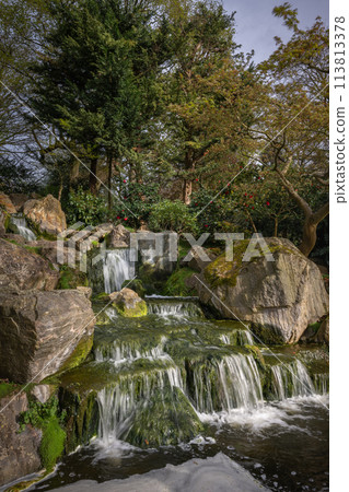 Waterfall in Kyoto Garden, a Japanese garden in Holland Park, London, UK. Holland Park is a public park with woods and gardens in the London borough of Kensington. 113813378