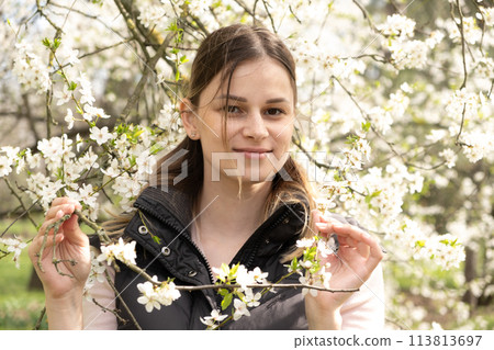 Happy thirty-year-old woman in cherry blossom orchard Happy thirty-year-old woman in cherry blossom orchard 113813697